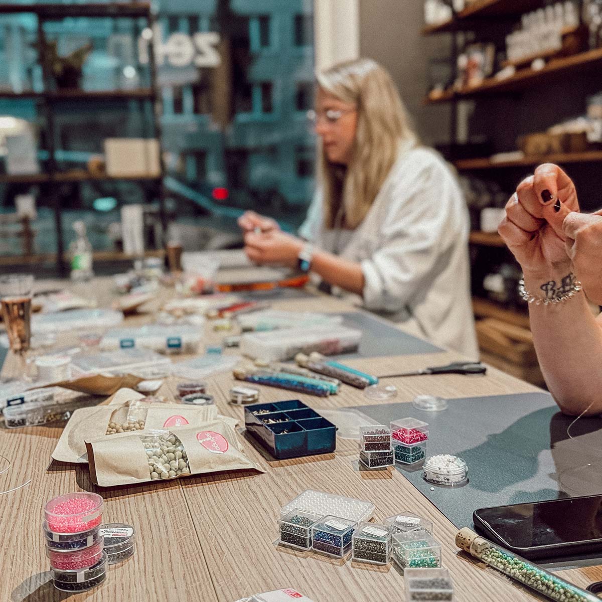 Teilnehmerinnen beim Perlen-Workshop in Düsseldorf gestalten individuelle Schmuckstücke mit bunten Perlen
