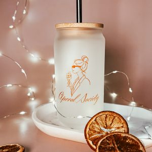 Satiniertes Trinkglas „Aperol Society“ mit Bambusdeckel und Edelstahlstrohhalm – Produktfoto mit Trockenorangen und Lichterkette