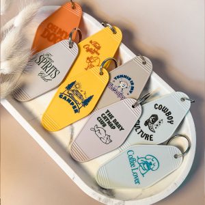 Bunte Retro-Schlüsselanhänger im Motel-Stil mit verschiedenen UV-bedruckten Designs auf einem Tablett