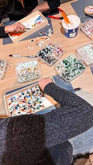 Teilnehmer gestalten Mosaik-Tabletts im DIY Workshop bei zehn null zwo in Düsseldorf