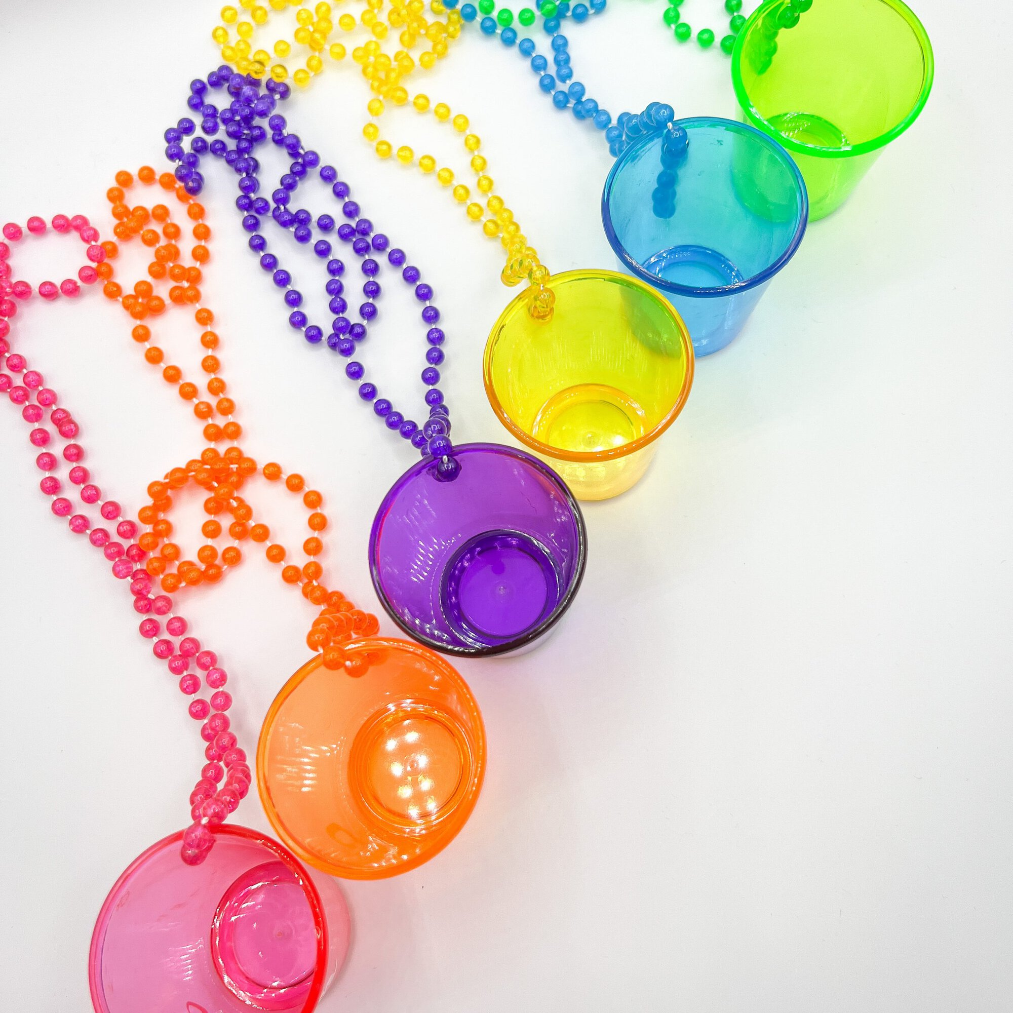 Bunte transparente Shotbecher in Neonfarben mit Partyketten