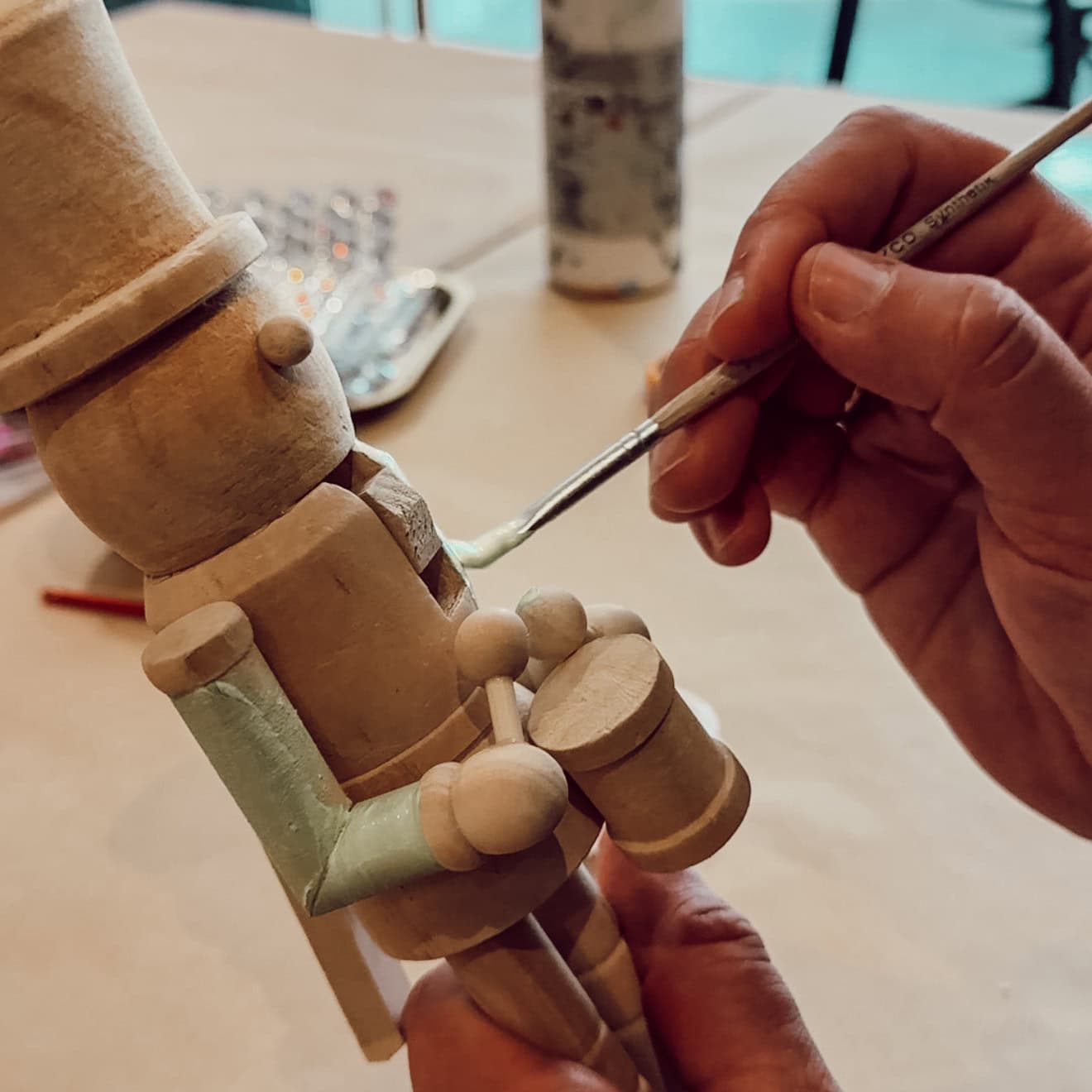 Holz-Nussknacker wird im Workshop mit Farbe bemalt